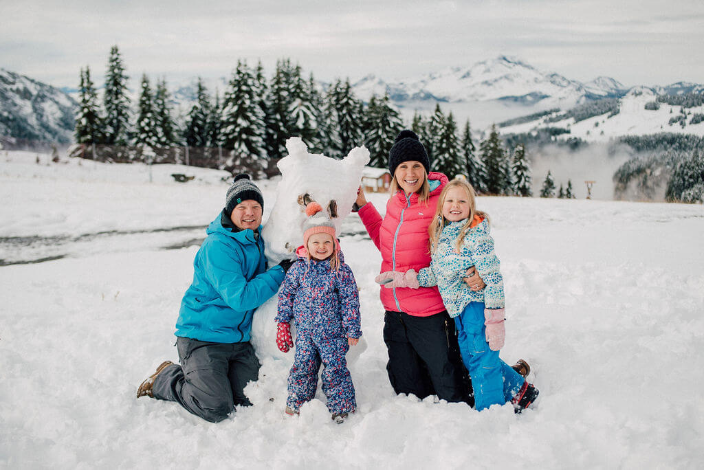 photoshoot for a family playing with a snowman in Avoriaz (French Alps) on their ski holiday