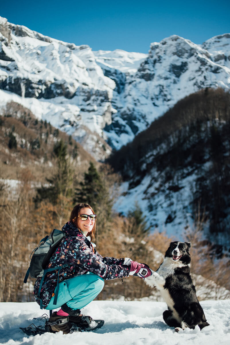 photoshoot for a family a girl with a dog snowshoeing in the snow in Morzine Avoriaz (French Alps) on their ski holiday