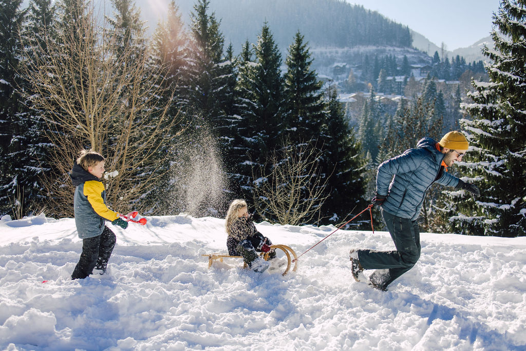 Children having fun with dad in snow in Morzine